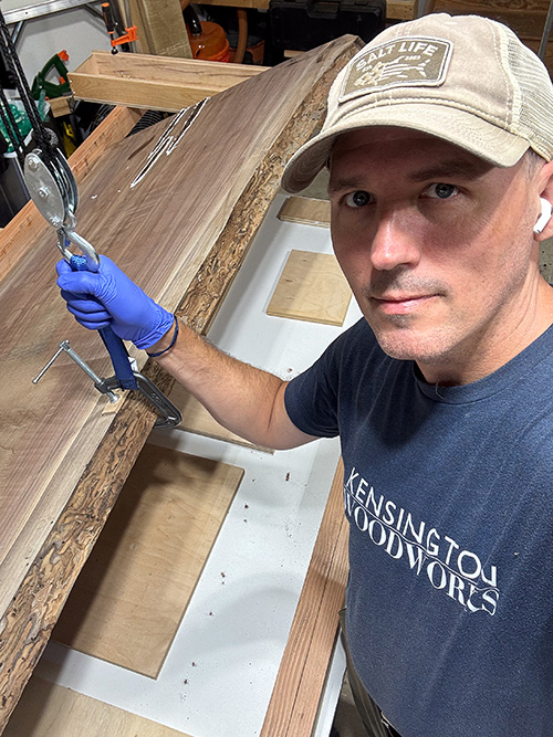 Joshua Groboski at the bench, using a pulley to flip a walnut slab